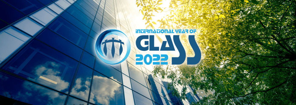 Logotypen för International year of glass visas i motljus framför en glasfasad och lövverk