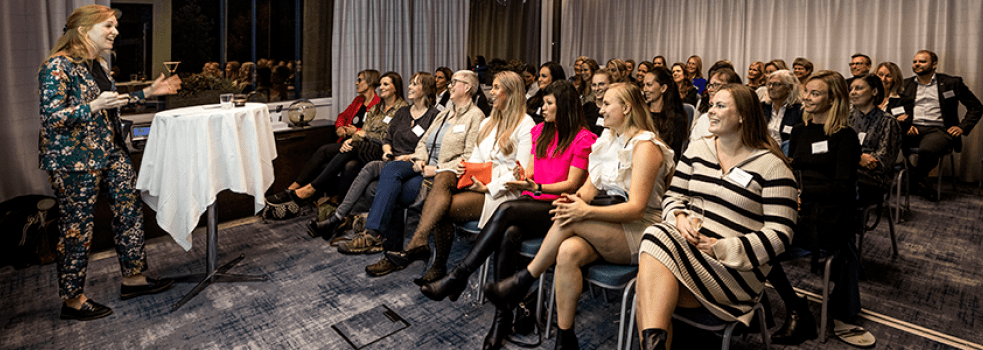 grupp av kvinnor i biosittning tittar glatt på kvinnligt konferencier